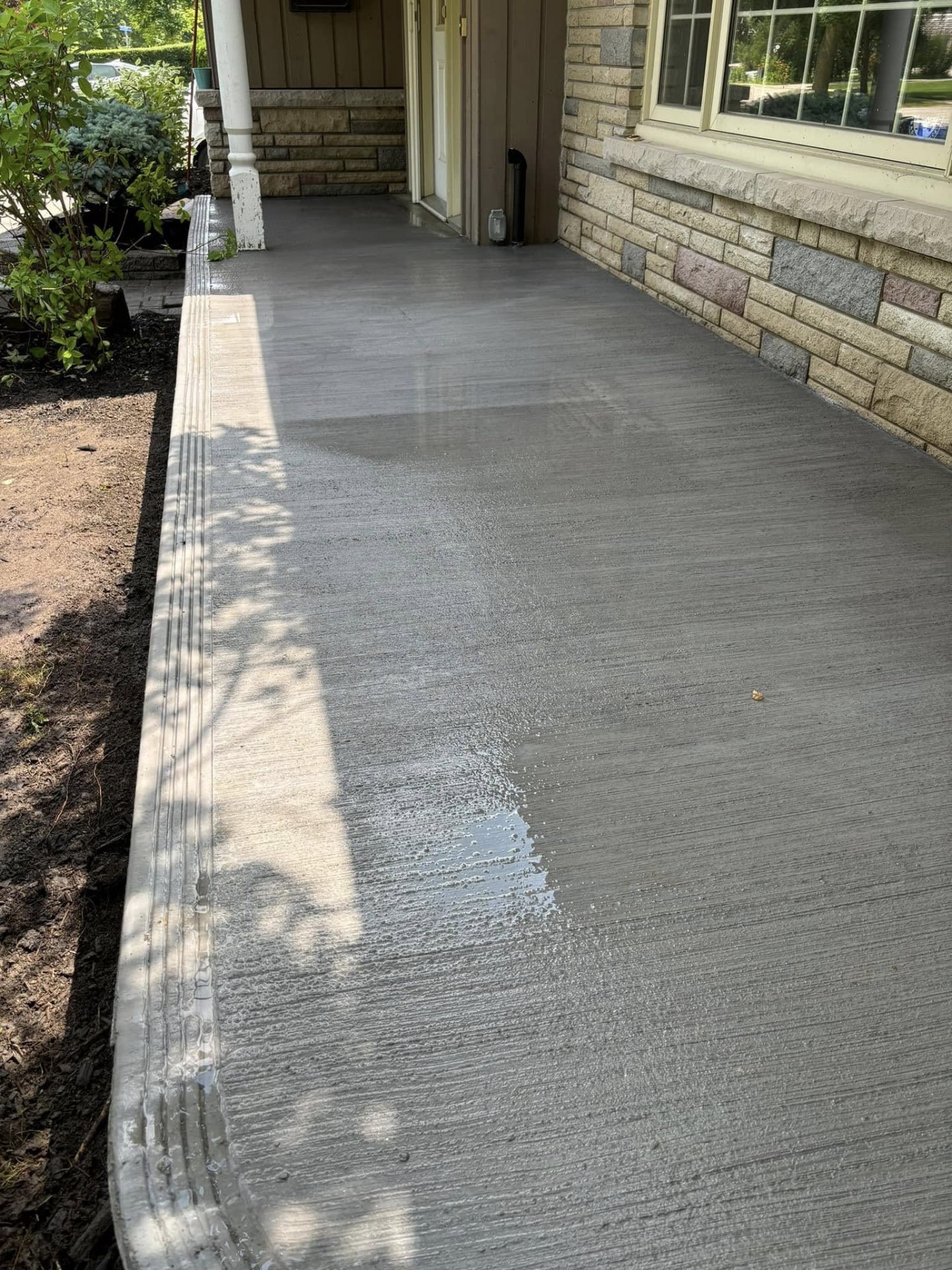 Long broom-finished concrete walkway running alongside a home