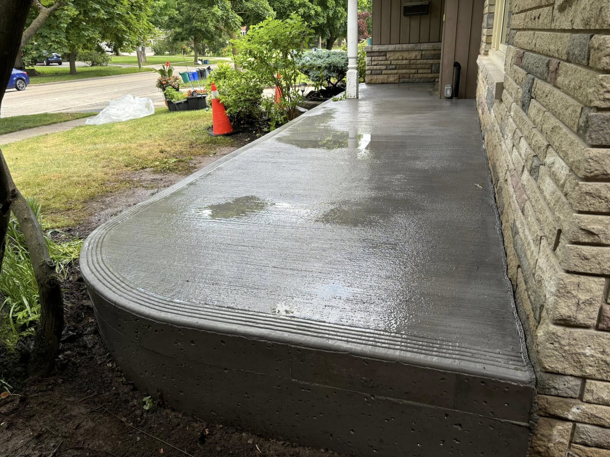 Freshly finished curved concrete porch slab with broom finish
